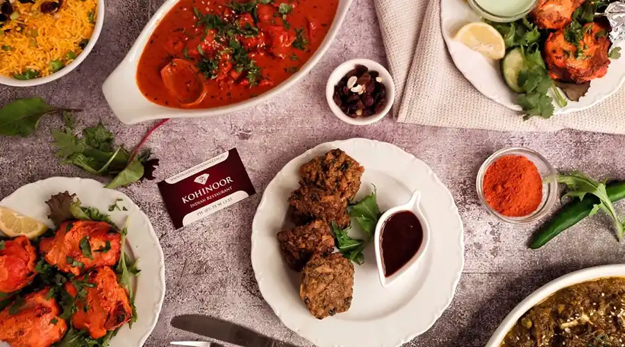 Top-down image of authentic indian dishes on a restaurant table