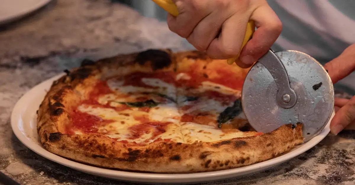 Chef cuts woodfired pizza at Gamelli Italian, Broadbeach
