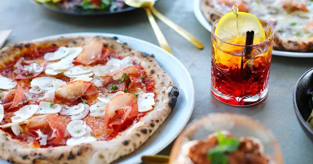 Pizza dish paired with cocktail at Goccia Italian Pizzeria
