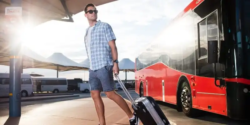 Man in front of a red bus