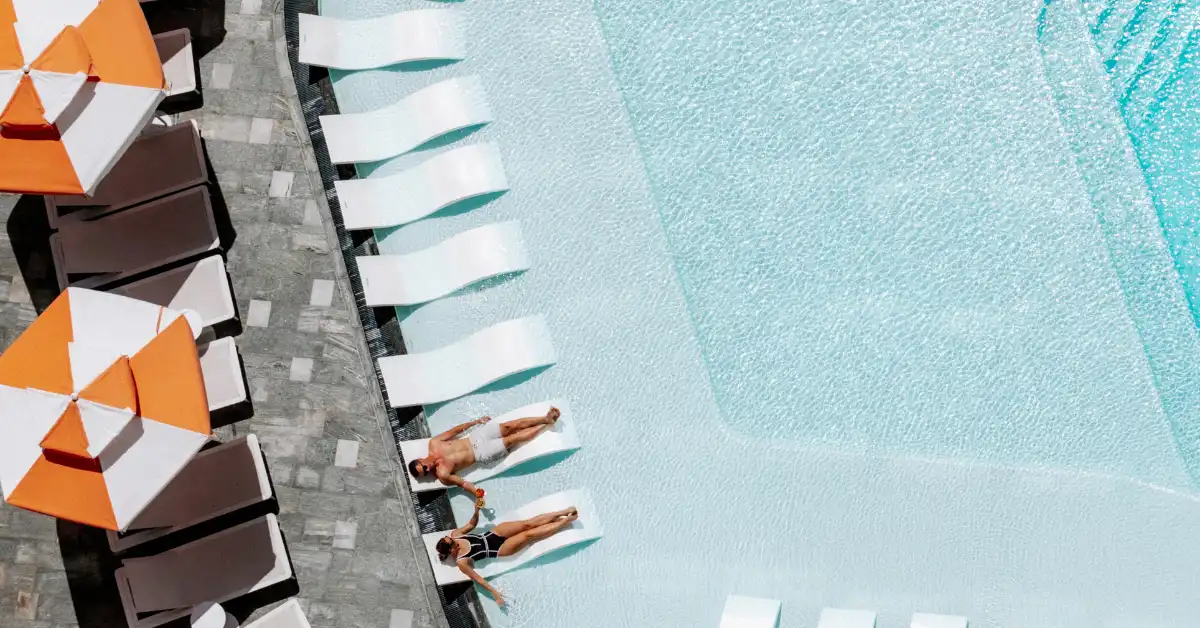 A couple lounges in Isoletto Pool Club with cocktails