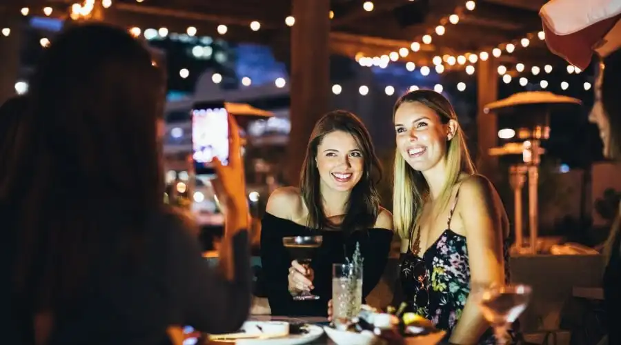 Ladies at rooftop bar taking a photo Ladies at rooftop bar taking a photo