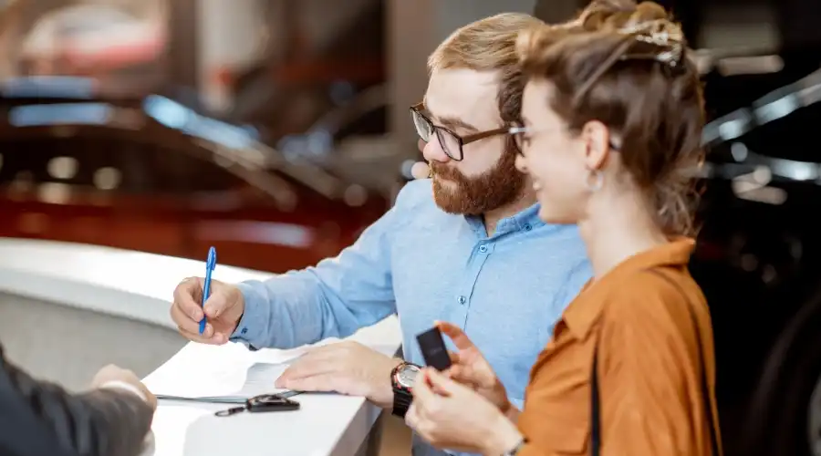 A couple signing a contract for a car rental