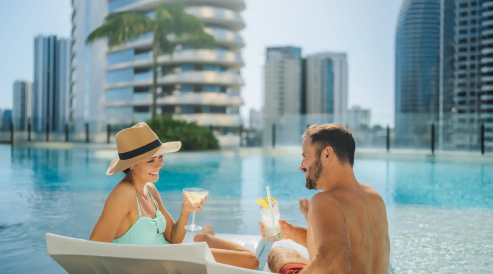 Smiling couple with cocktails in hand at Isoletto Pool Club