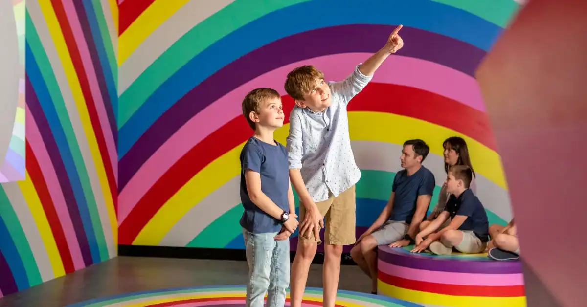 Two boys look at a rainbow exhibit in HOTA