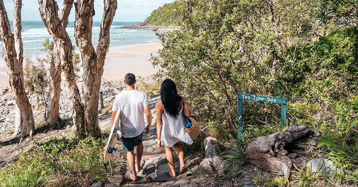 Couple heading to Tea Tree Bay for a surf