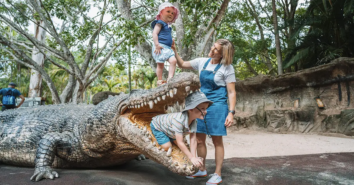 Family play with crocodile statue at Australia Zoo