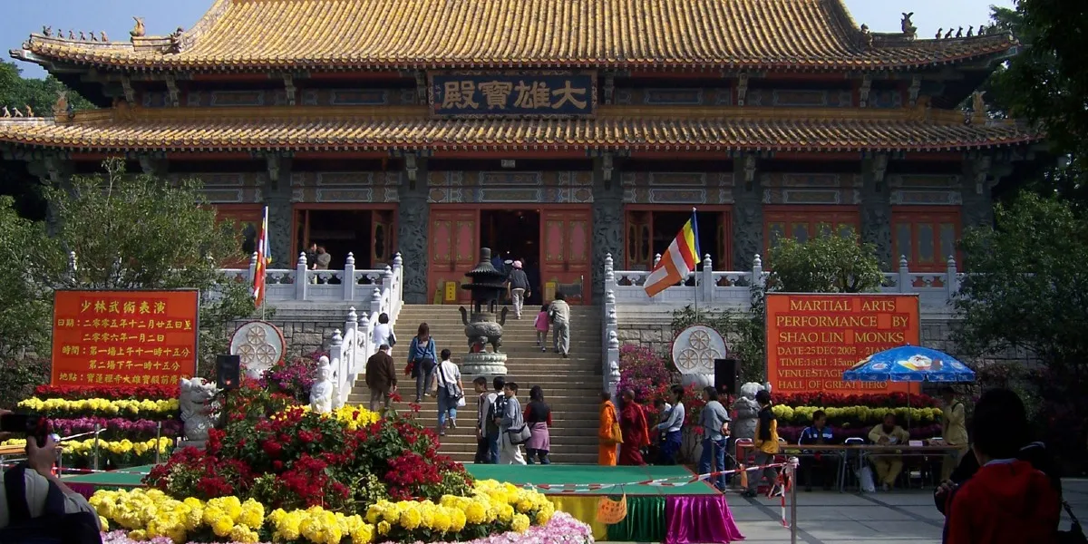 游客漫步昂坪市集，背景可见宝莲禅寺 
