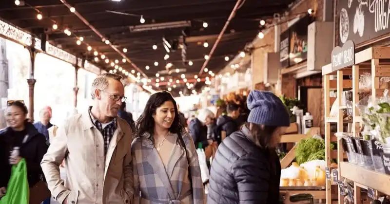 A couple walking through South Melbourne Markets A couple walking through South Melbourne Markets