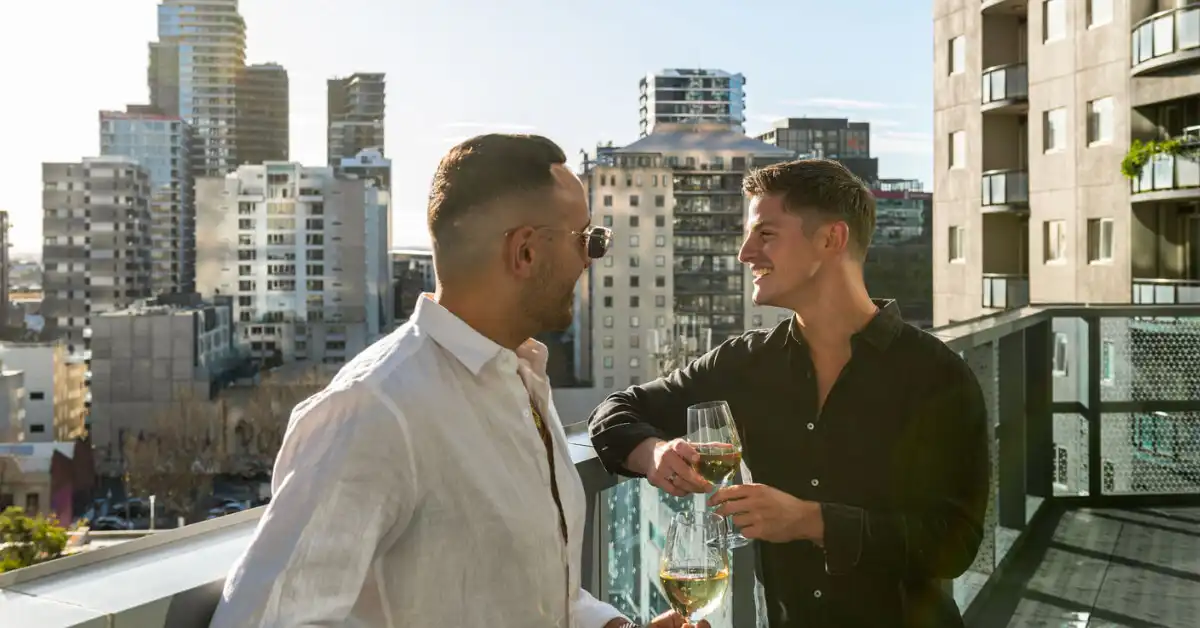 Two men prepare for Grand Final day on their room balcony at Dorsett Melbourne.