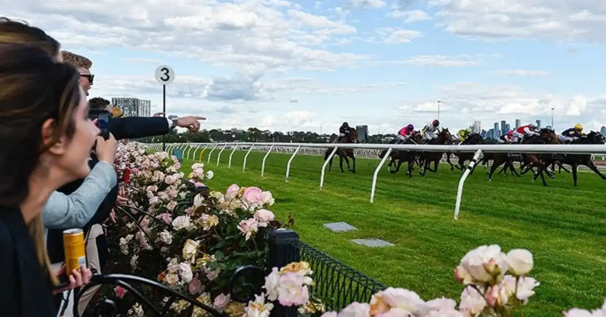 Spectators watch a Melbourne Cup race from the lawn