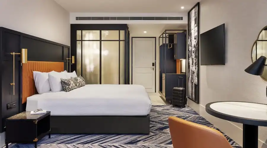 Interior of a stylish room at Dorsett Melbourne, featuring modern decor, a comfortable bed, elegant furnishings, and ambient lighting, offering a cosy stay in the city.