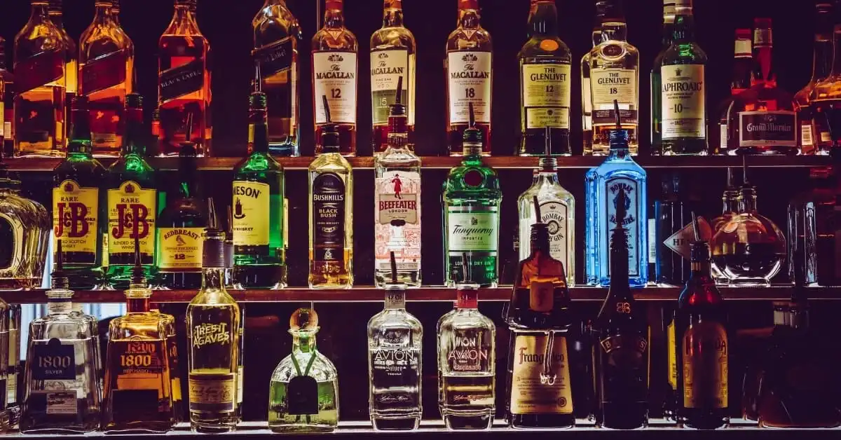 An array of spirits and liqueurs on display at a bar, offering diverse choices for cocktail enthusiasts.