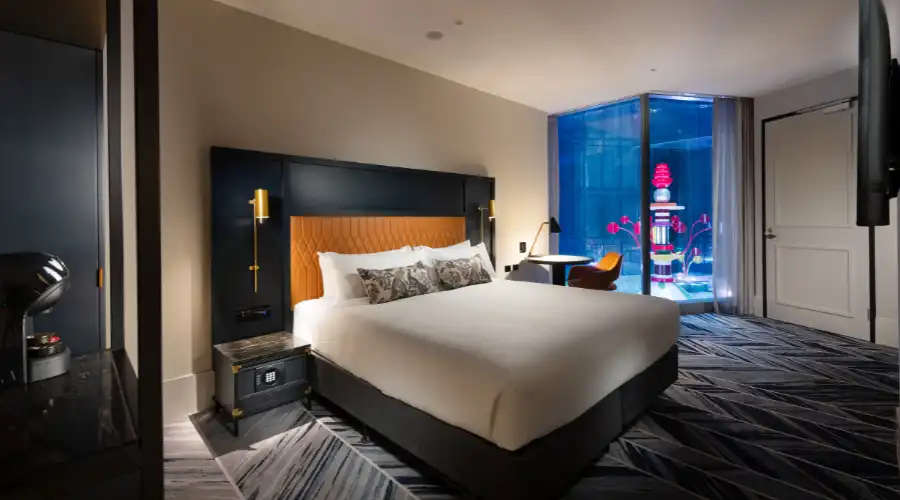 A stylish guest room at Dorsett Melbourne, featuring modern decor, plush bedding, and contemporary amenities for comfort.