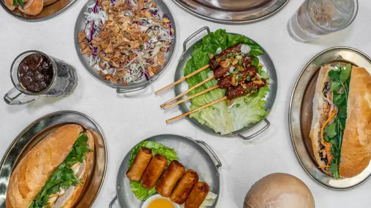 Vietnamese cuisine featuring fresh banh mi, crispy spring rolls, grilled meat skewers, and salad
