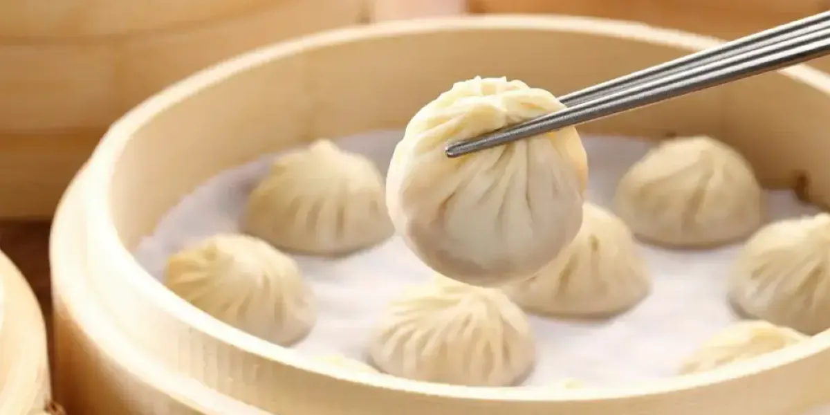 A steamed soup dumplings over a bamboo steamer