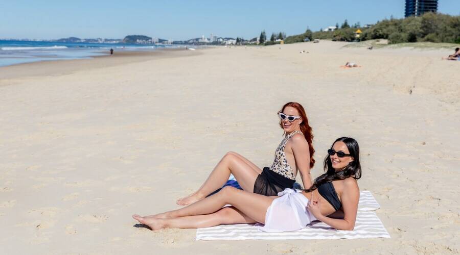 Two women lying on the beach