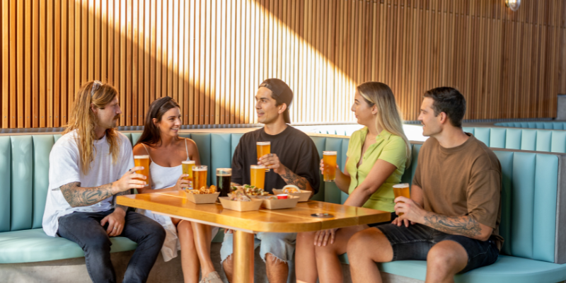 People sitting at a bar with beers