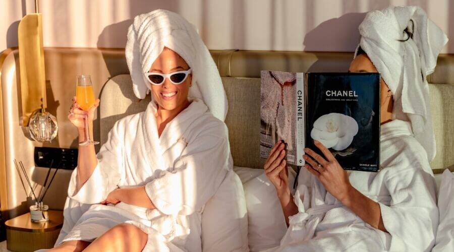 Two women in white robes in a Dorsett Gold Coast hotel room