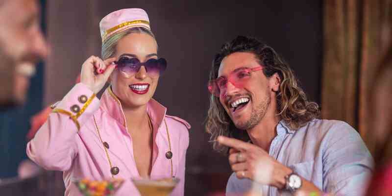 Woman dressed in pink and man wearing heart glasses